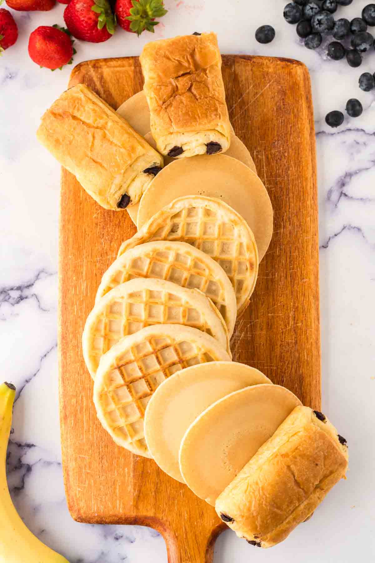 Placing waffles and pancakes on a wooden board.