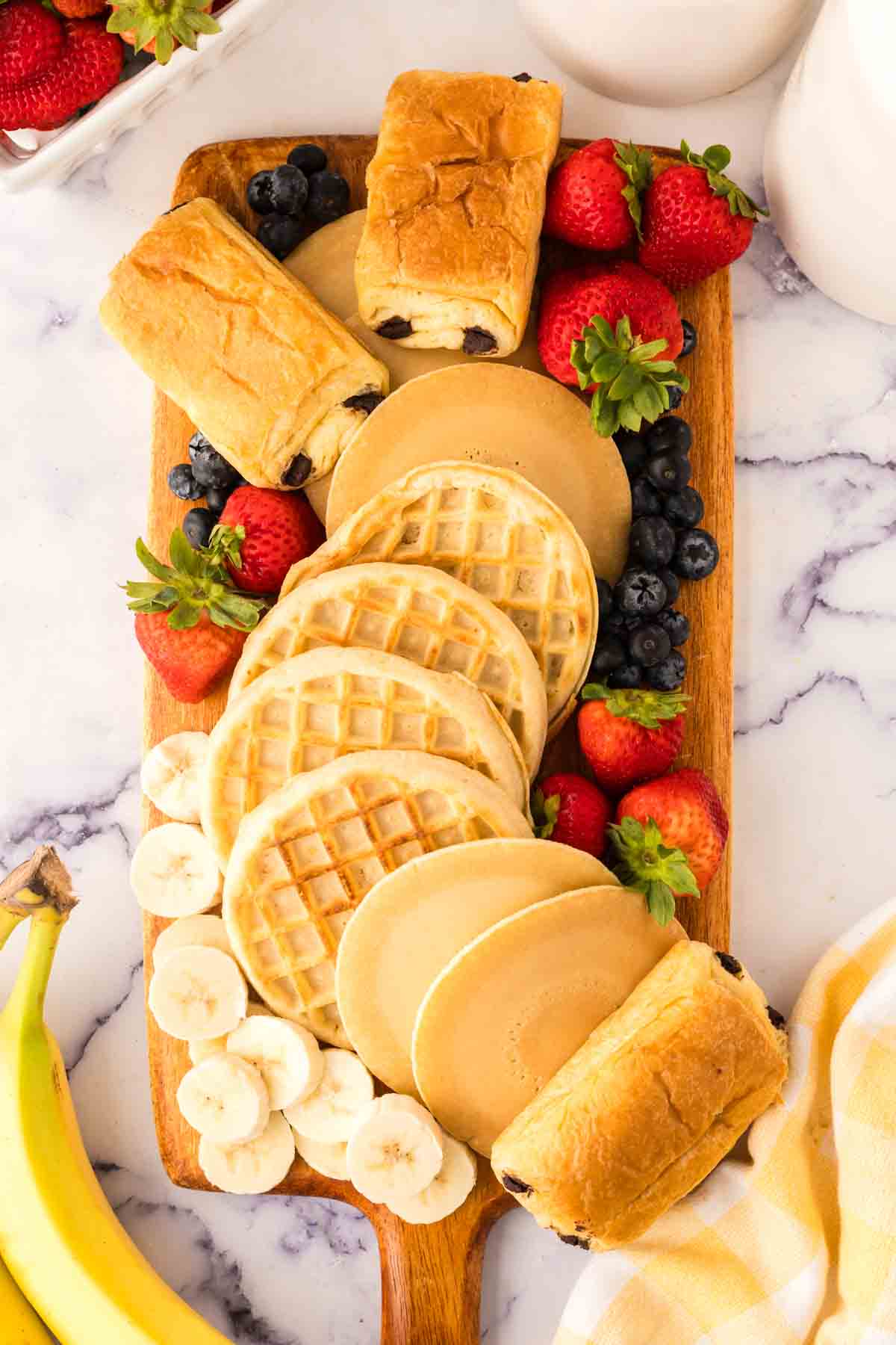 Adding in strawberries and bananas to the breakfast charcuterie board.