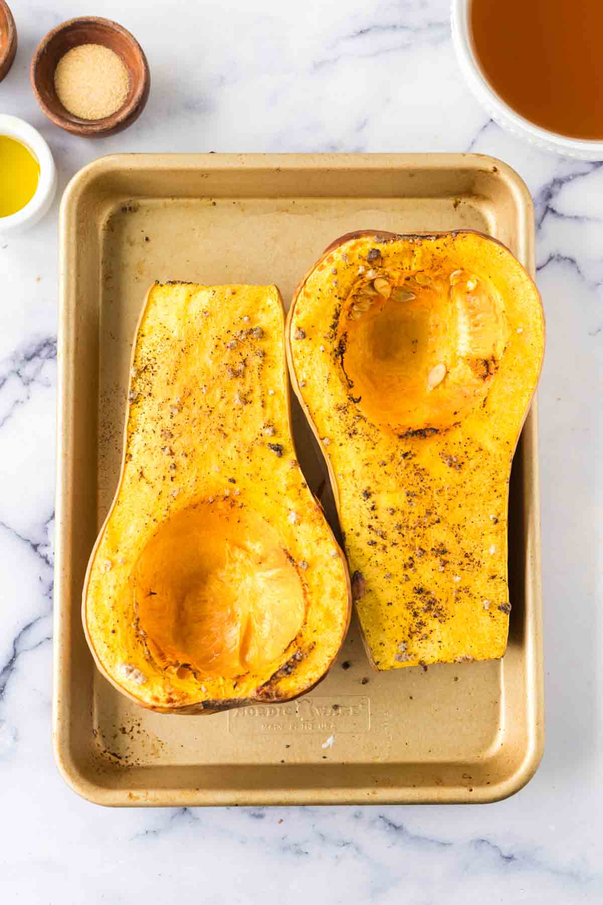sliced and open face roasted butternut squash on a baking dish