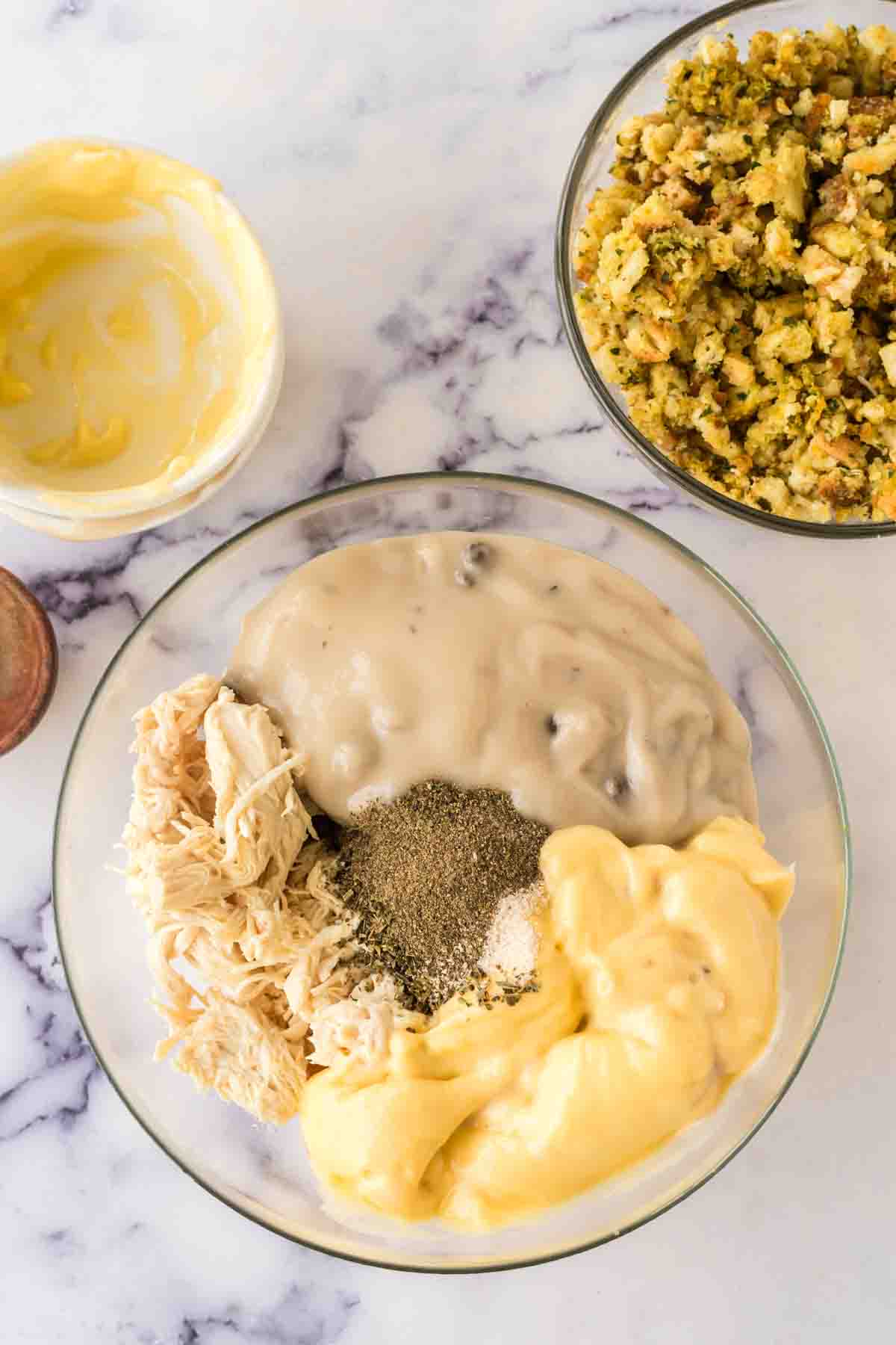 Mixing ingredients in a clear bowl for chicken and stuffing casserole. 