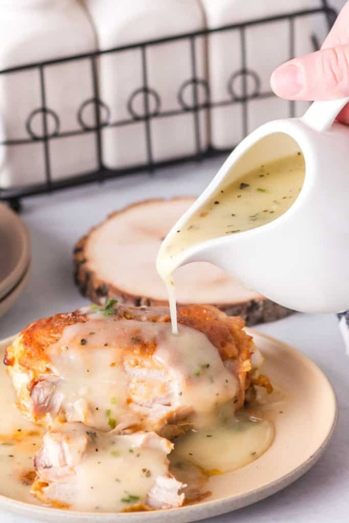 Chicken gravy being poured onto meat. 