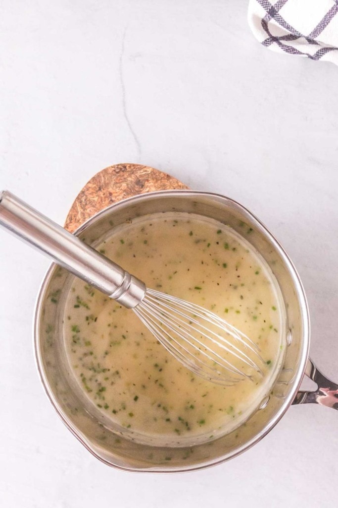 Whisking the chicken gravy in a pot.