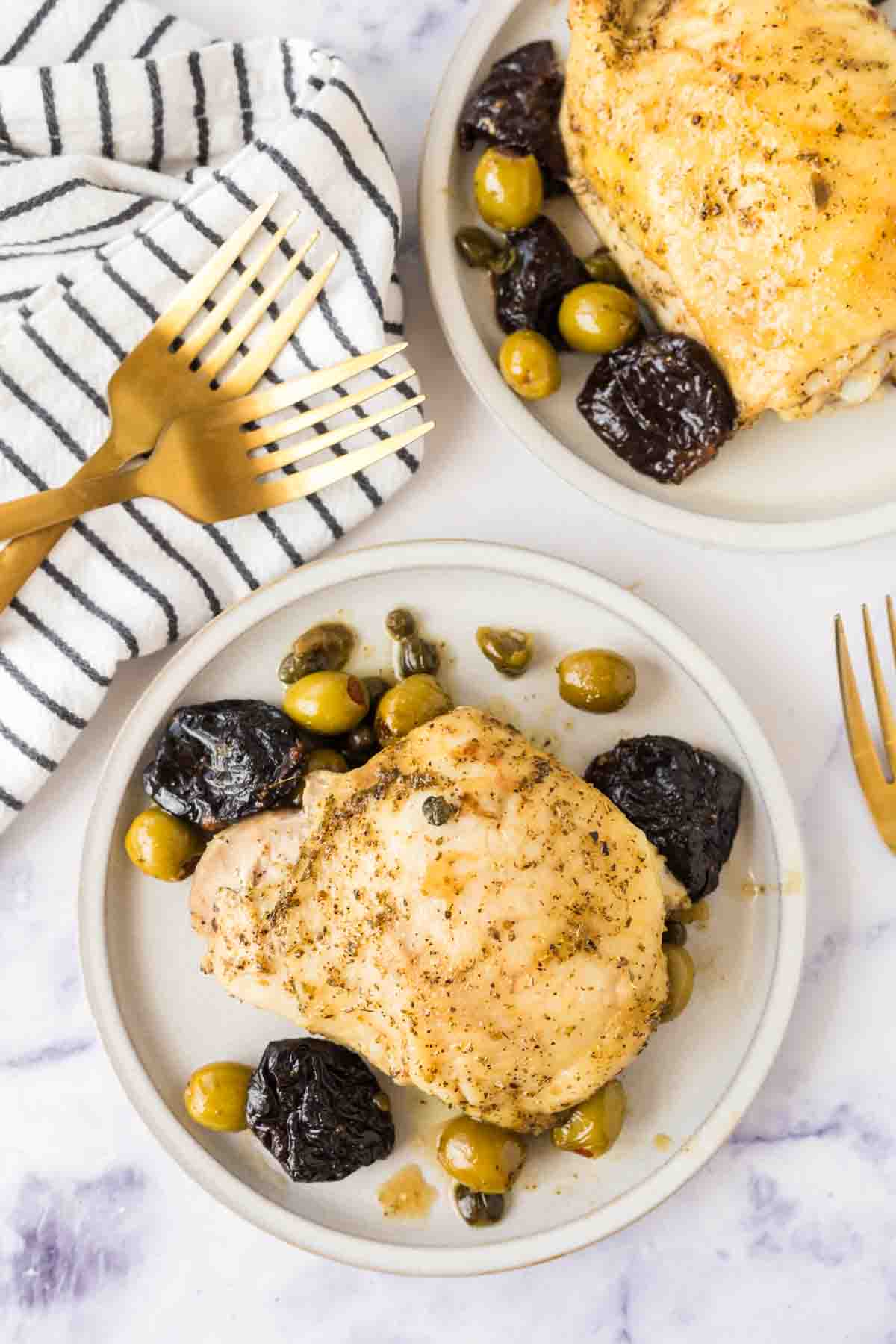round white plate with chicken marbella recipe with dates and olives around