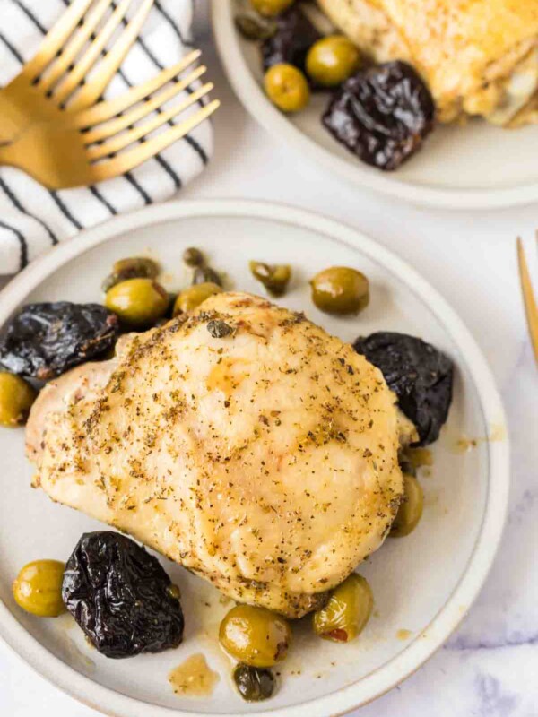 round white plate with chicken marbella recipe with dates and olives around