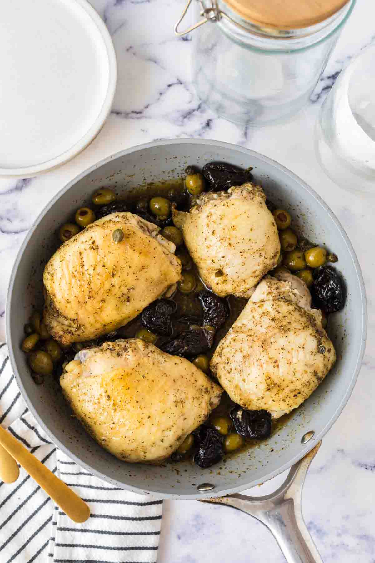 four breasts in a sautéed pan with chicken Marbella recipe inside