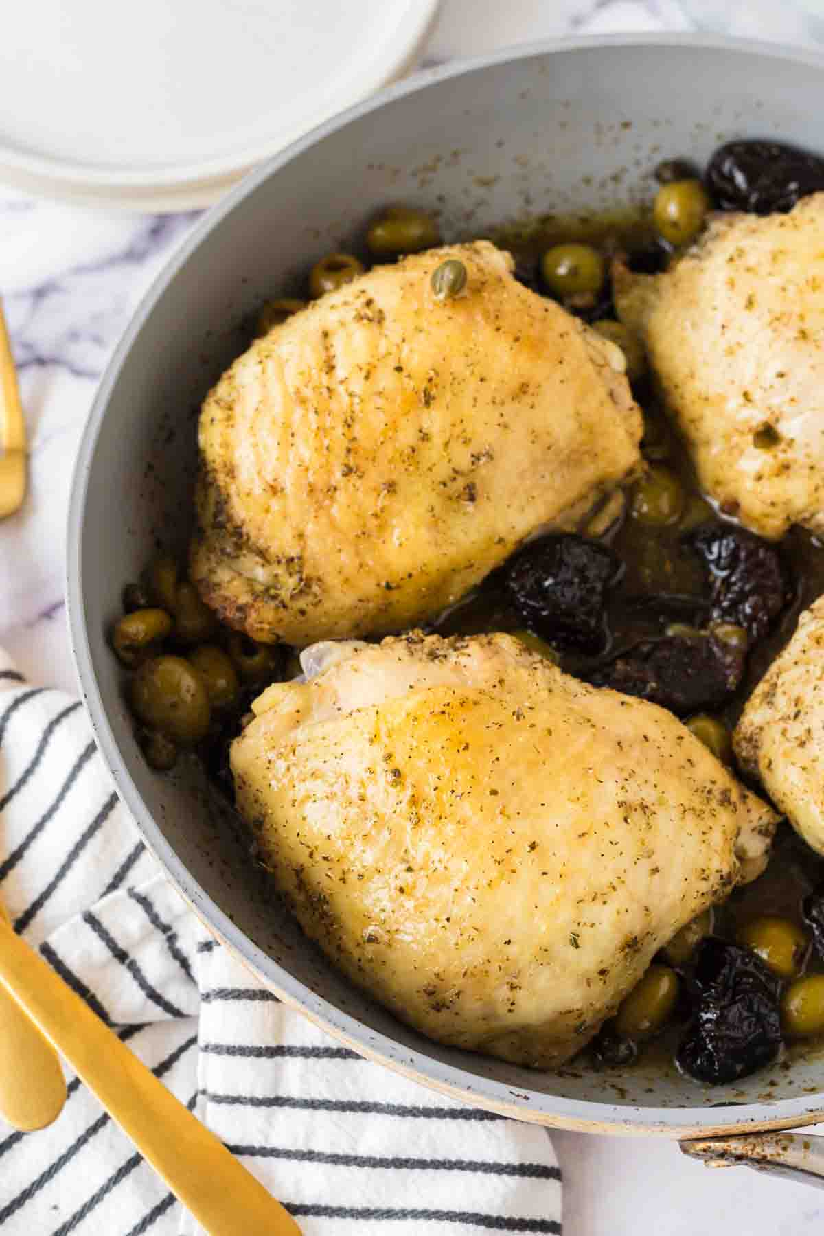 four breasts in a sautéed pan with chicken Marbella recipe inside