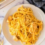 top view round white plate with chicken spaghetti