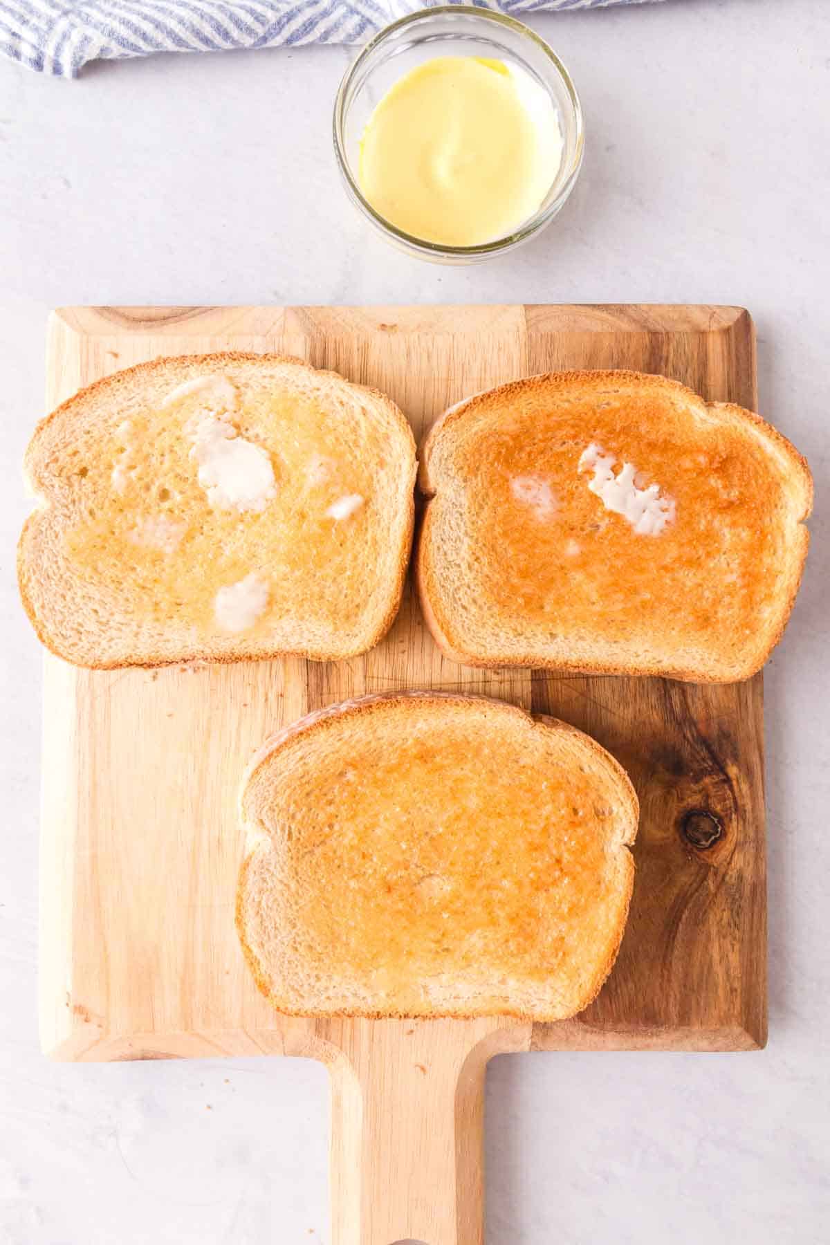 Toasted slices of bread on a cutting board.