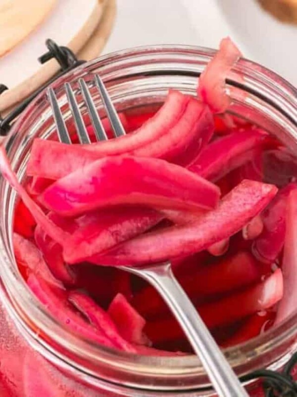 pickled red onions in a jar with a lid.
