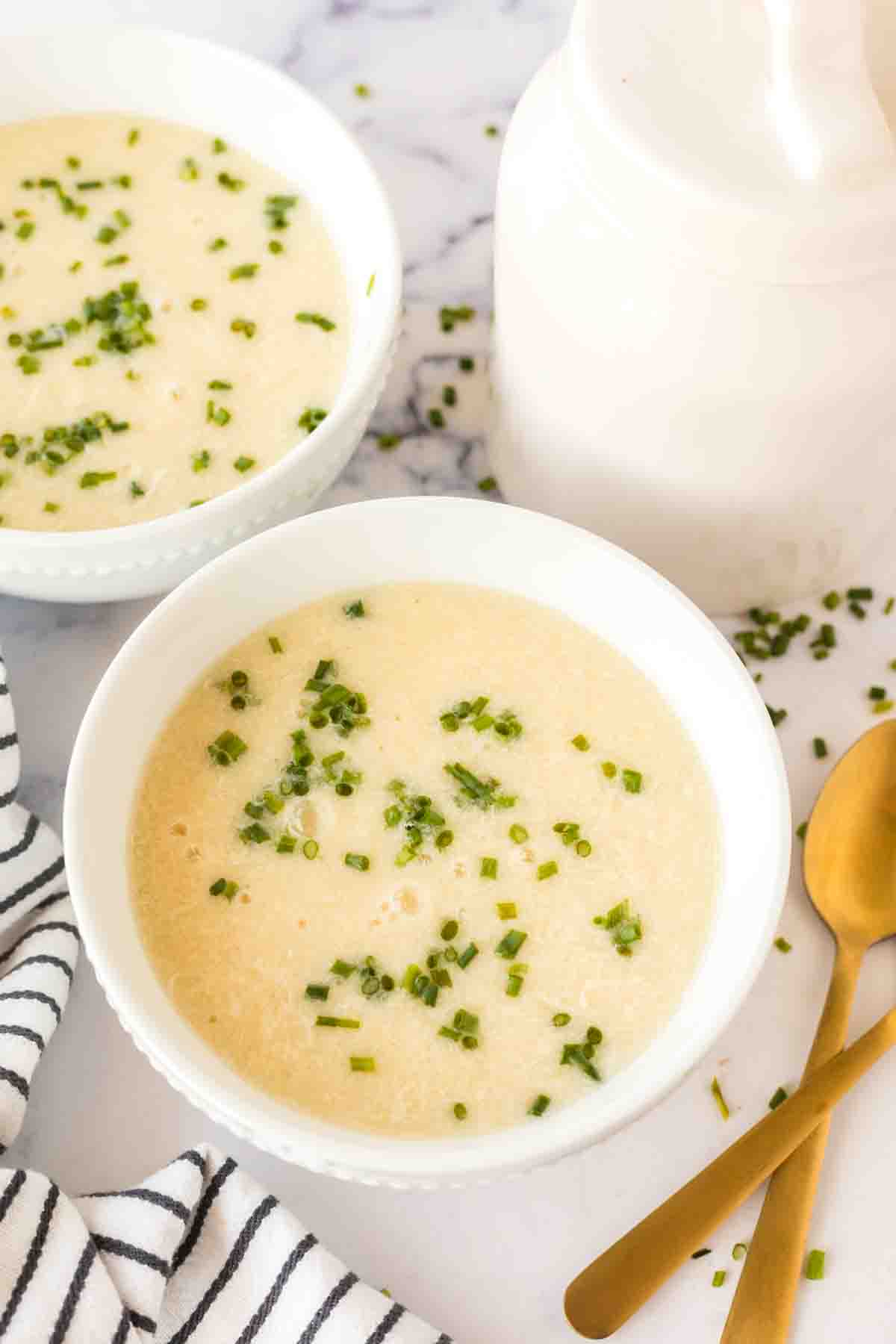 top view of egg drop soup in white bowls with herbs on top