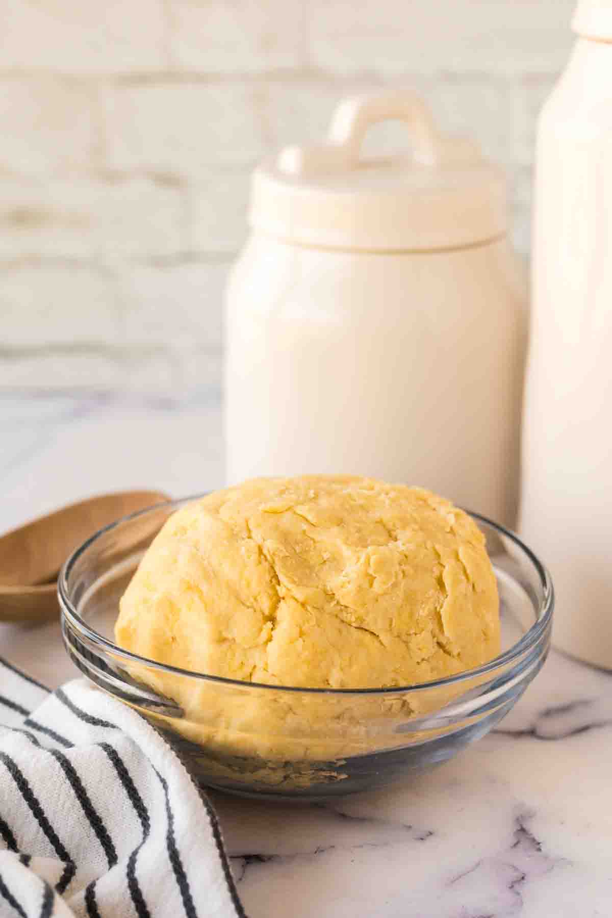 clear mixing bowl with empanada dough ball inside