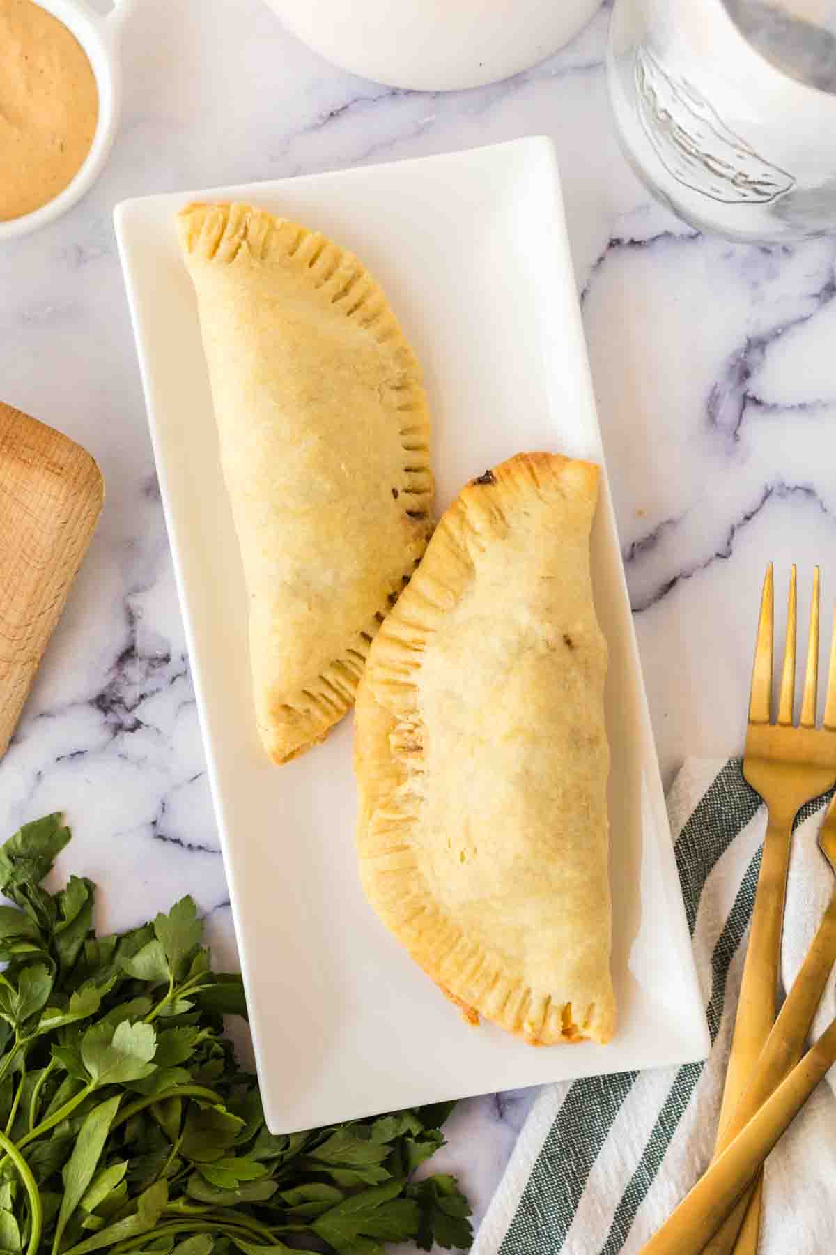 rectangle plate with two cooked empanadas