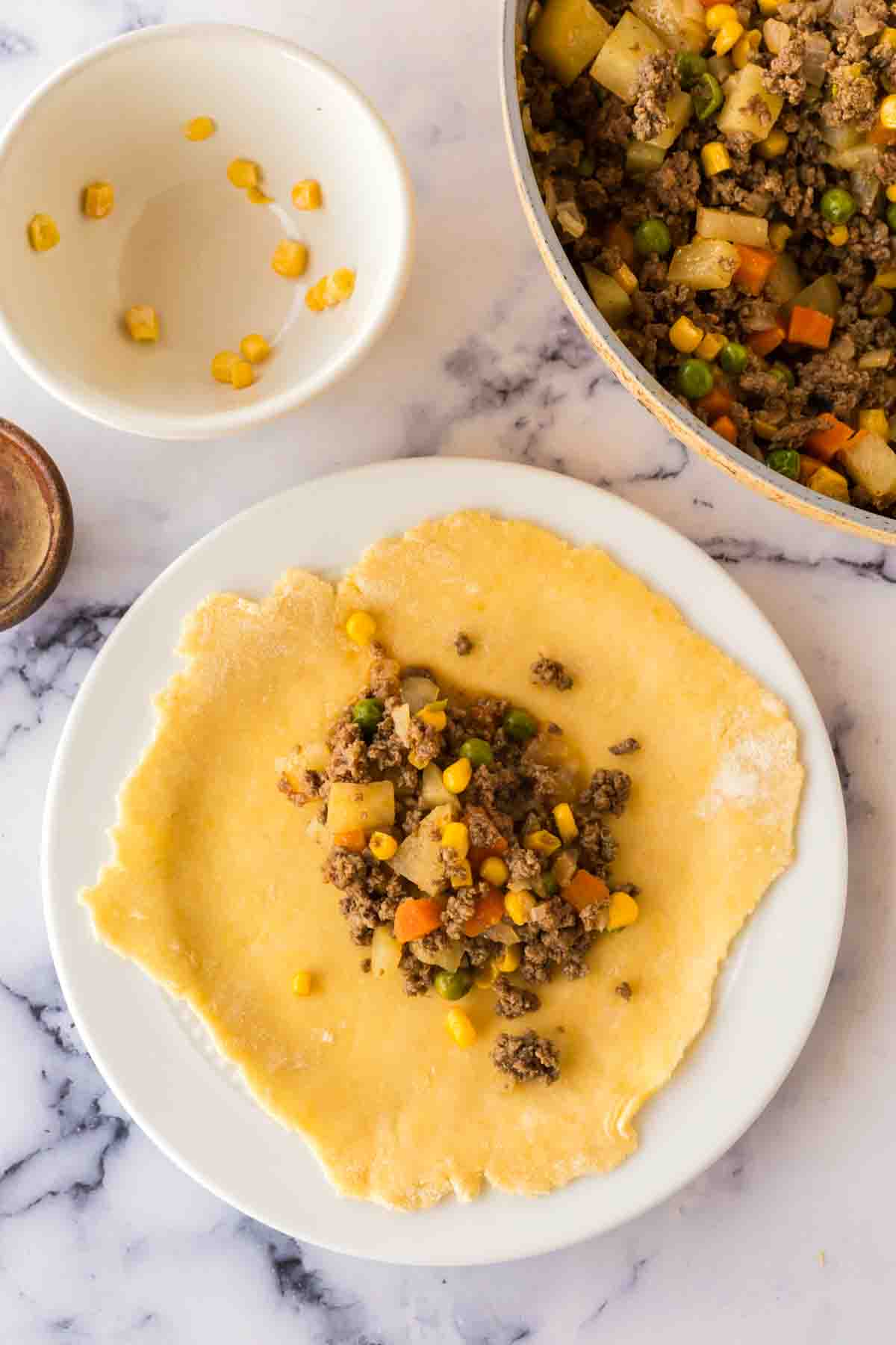 dough and filling on a plate with empanada ingredients