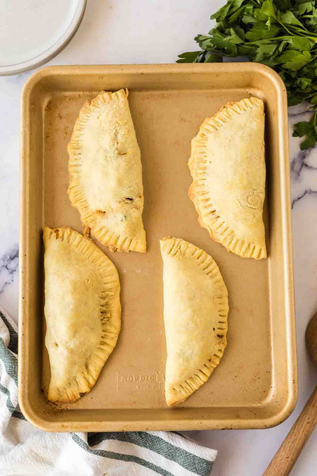 raw empanadas on a baking dish