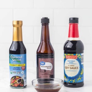 three bottles of ingredients for fish sauce substitutes with a small clear dish in front