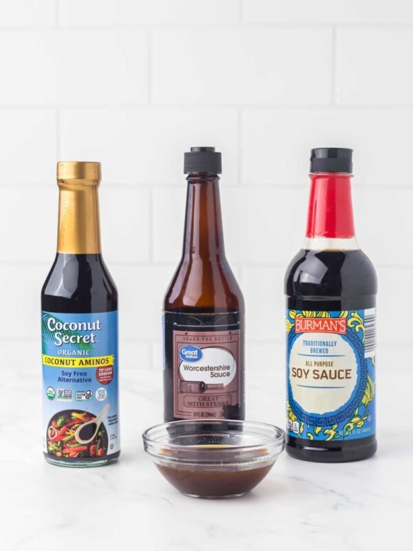 three bottles of ingredients for fish sauce substitutes with a small clear dish in front