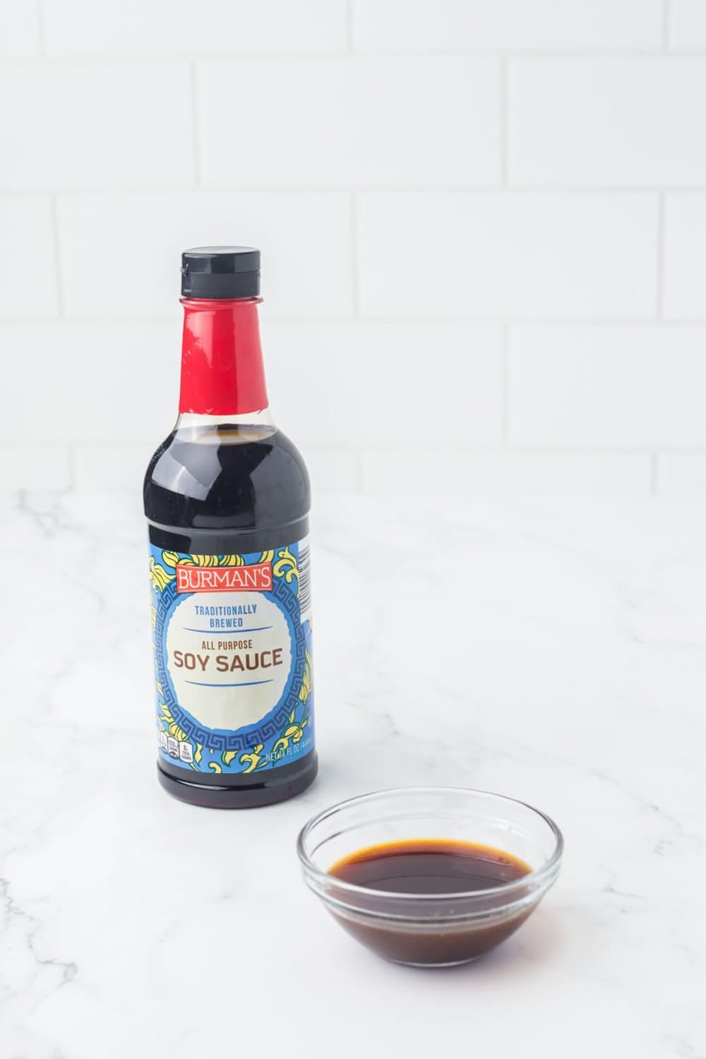 one bottle of soy sauce used for fish sauce substitutes with a small clear dish in front