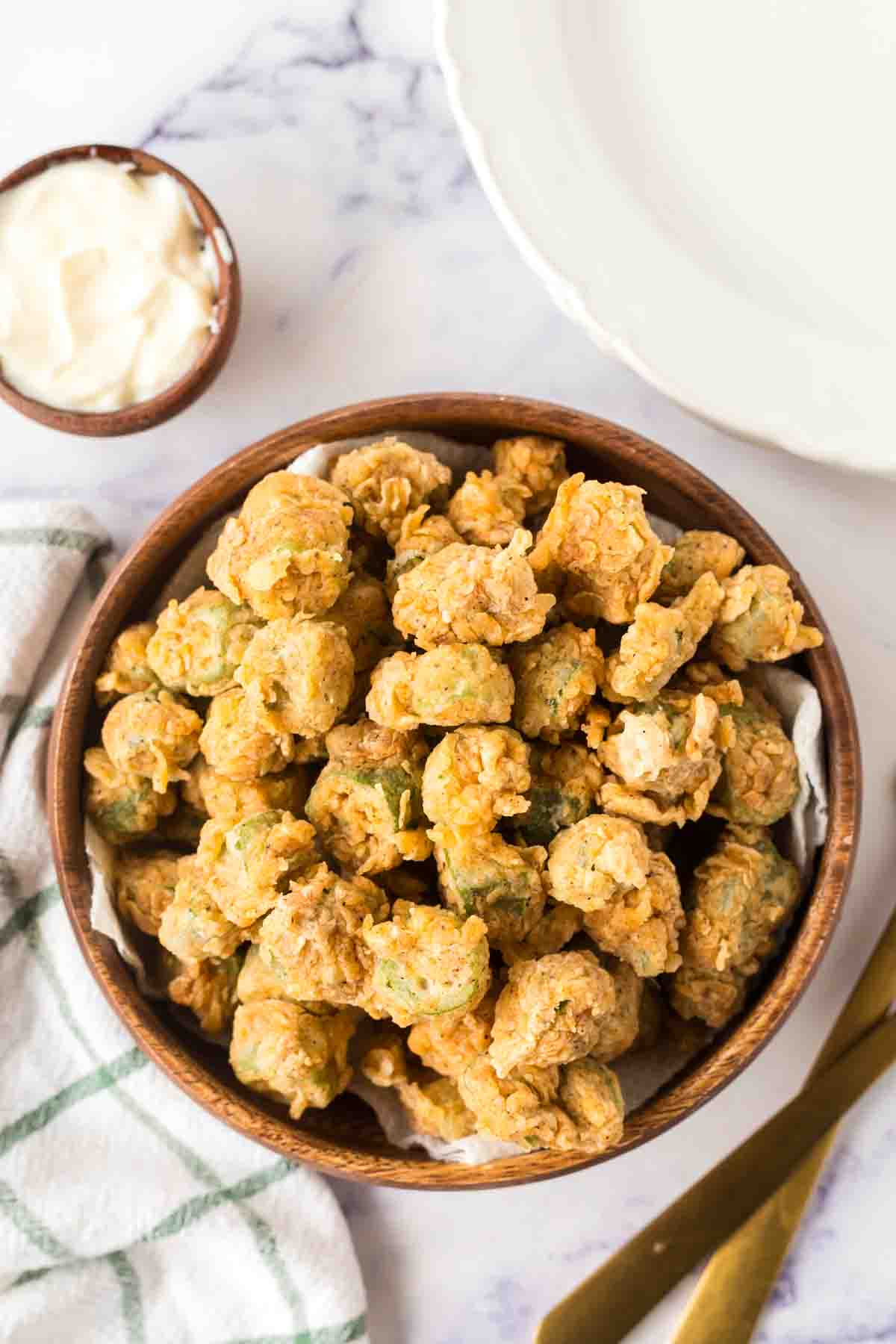 small wooden bowl with bits of fried okra stacked in