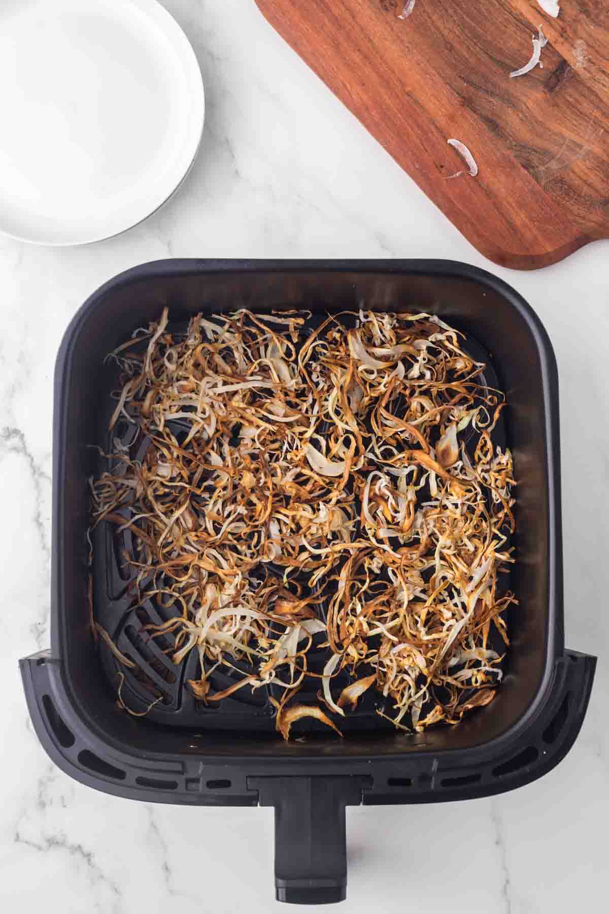 air fryer basked with fried onions