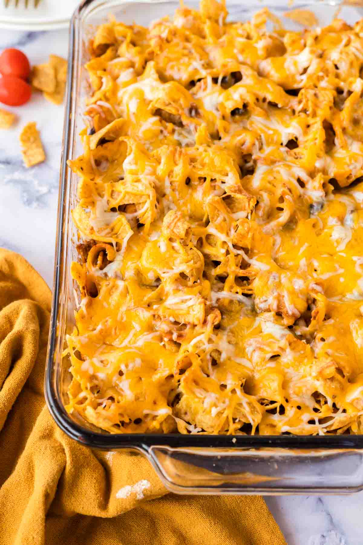 casserole dish with frito pie and melted cheese on top