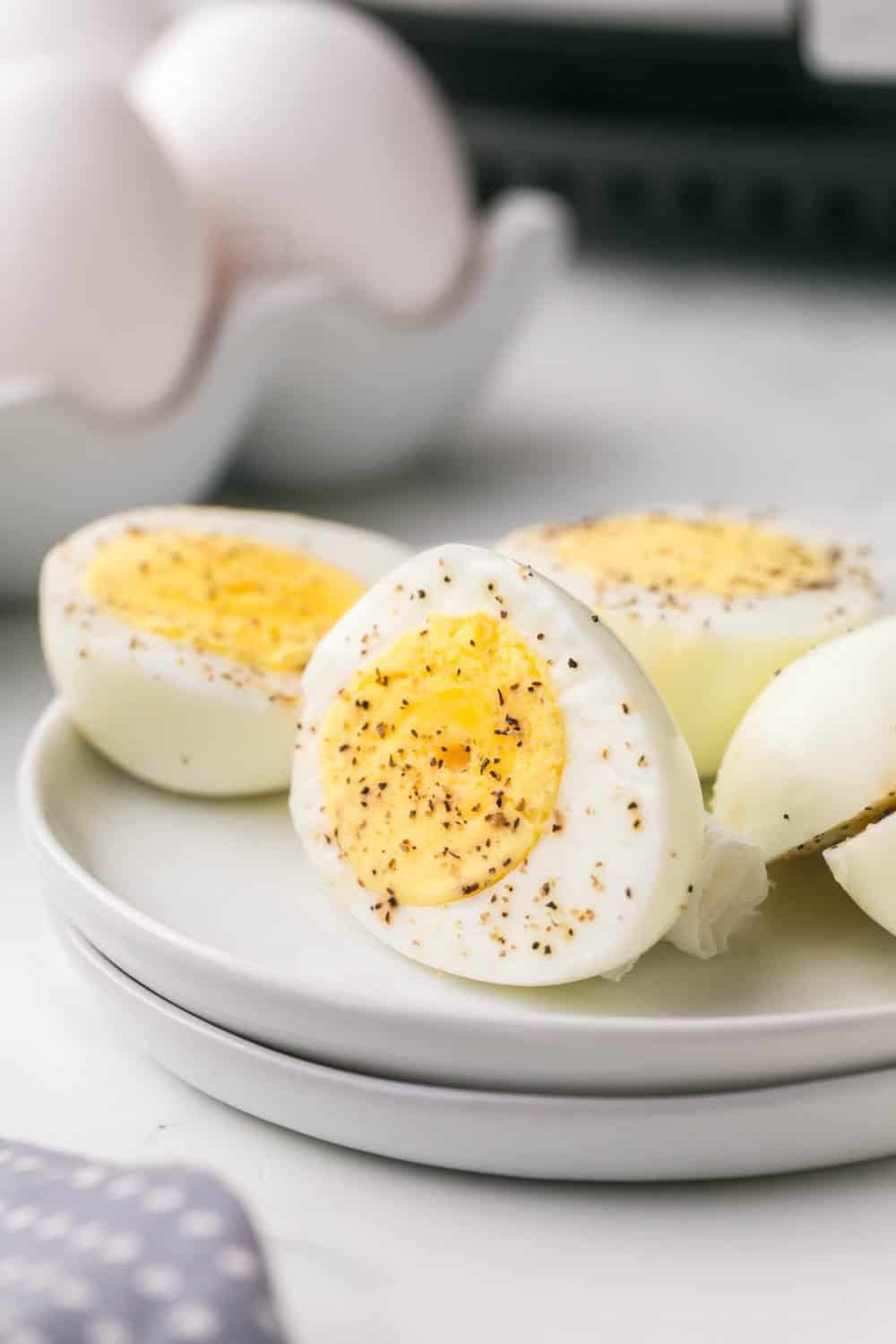 close up of a small plate of air fryer hard boiled egg sliced in half and seasoned