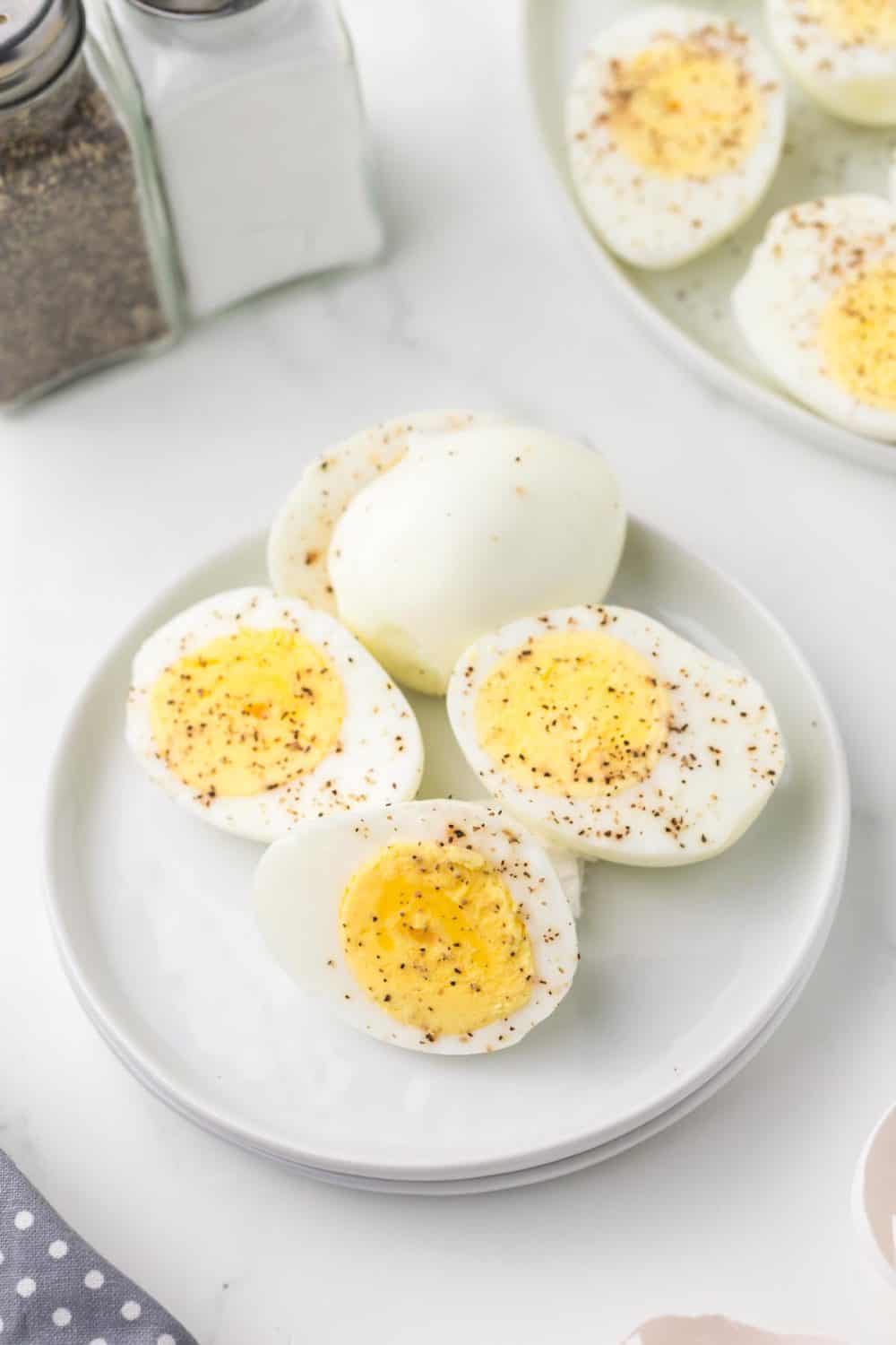 close up of a small plate of air fryer hard boiled egg sliced in half and seasoned