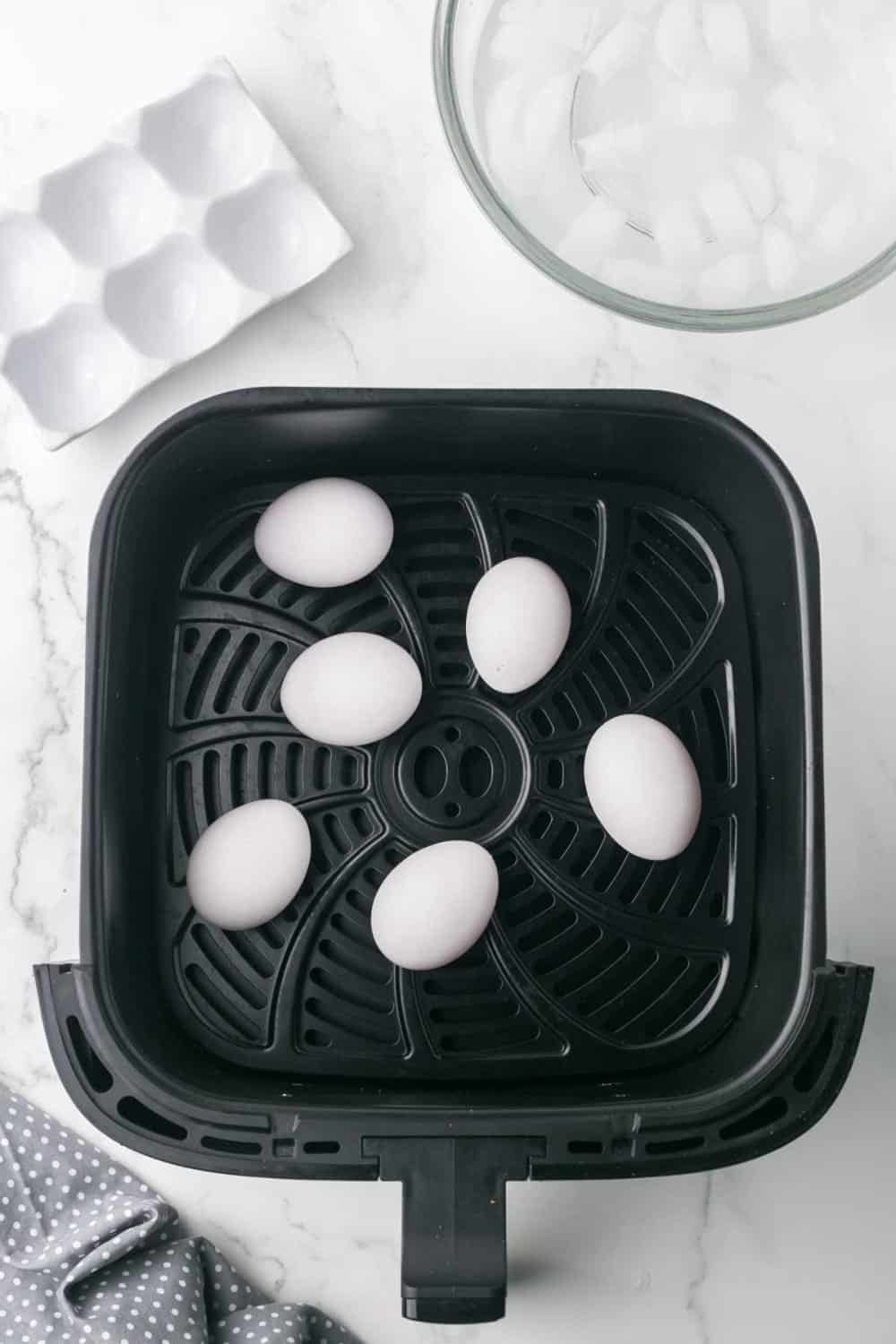 air fryer basket with whole eggs inside