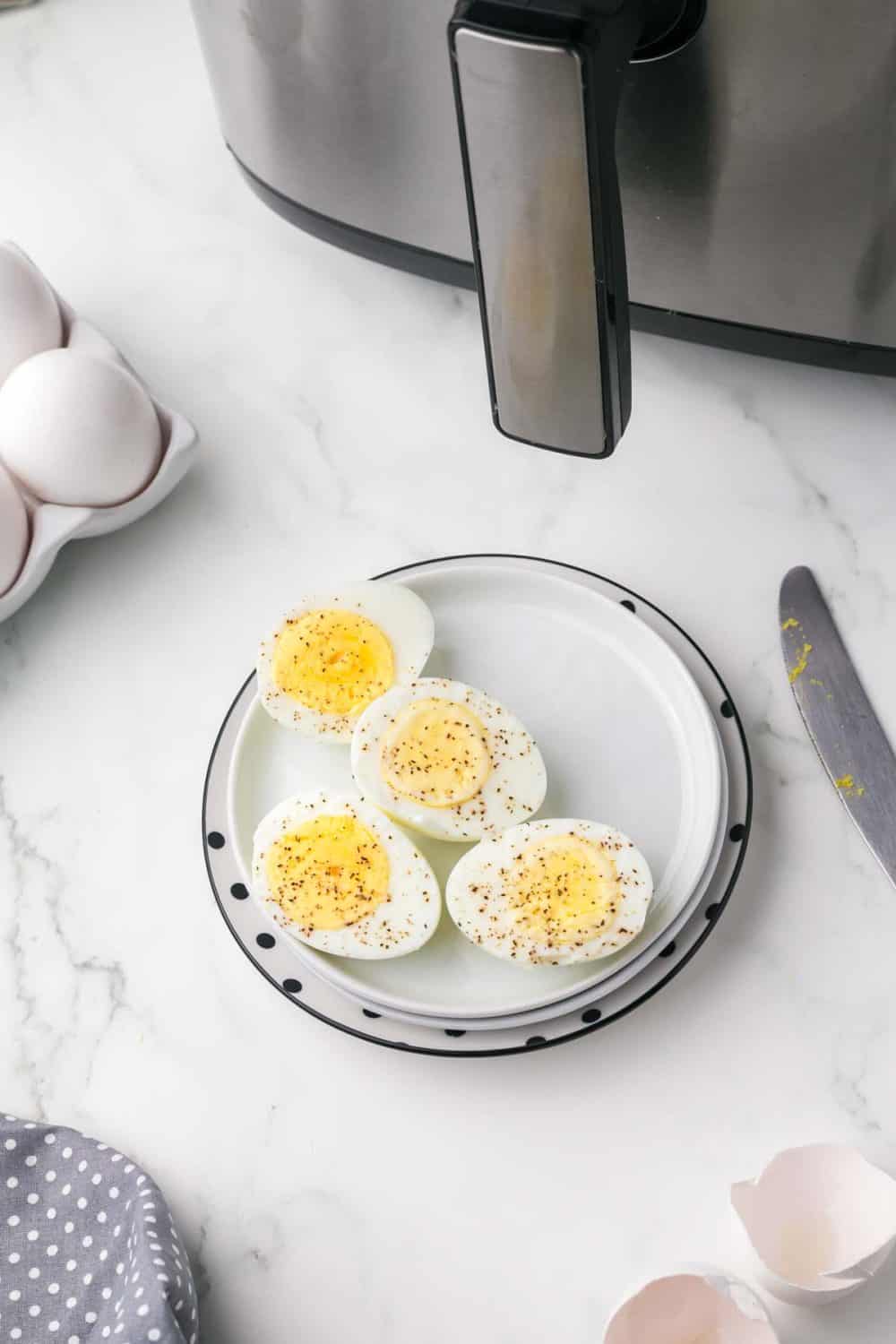 a small plate with four halves of seasoned hard boiled eggs