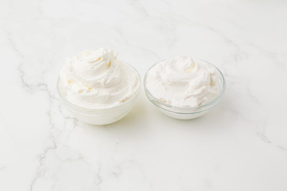 two small clear bowls of whipped cream