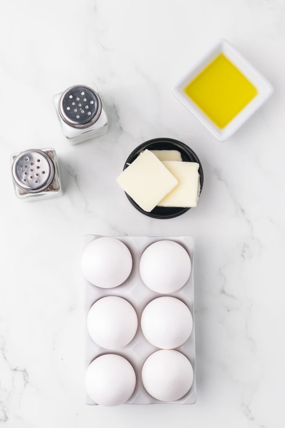 six eggs with butter and oil ready to be fried