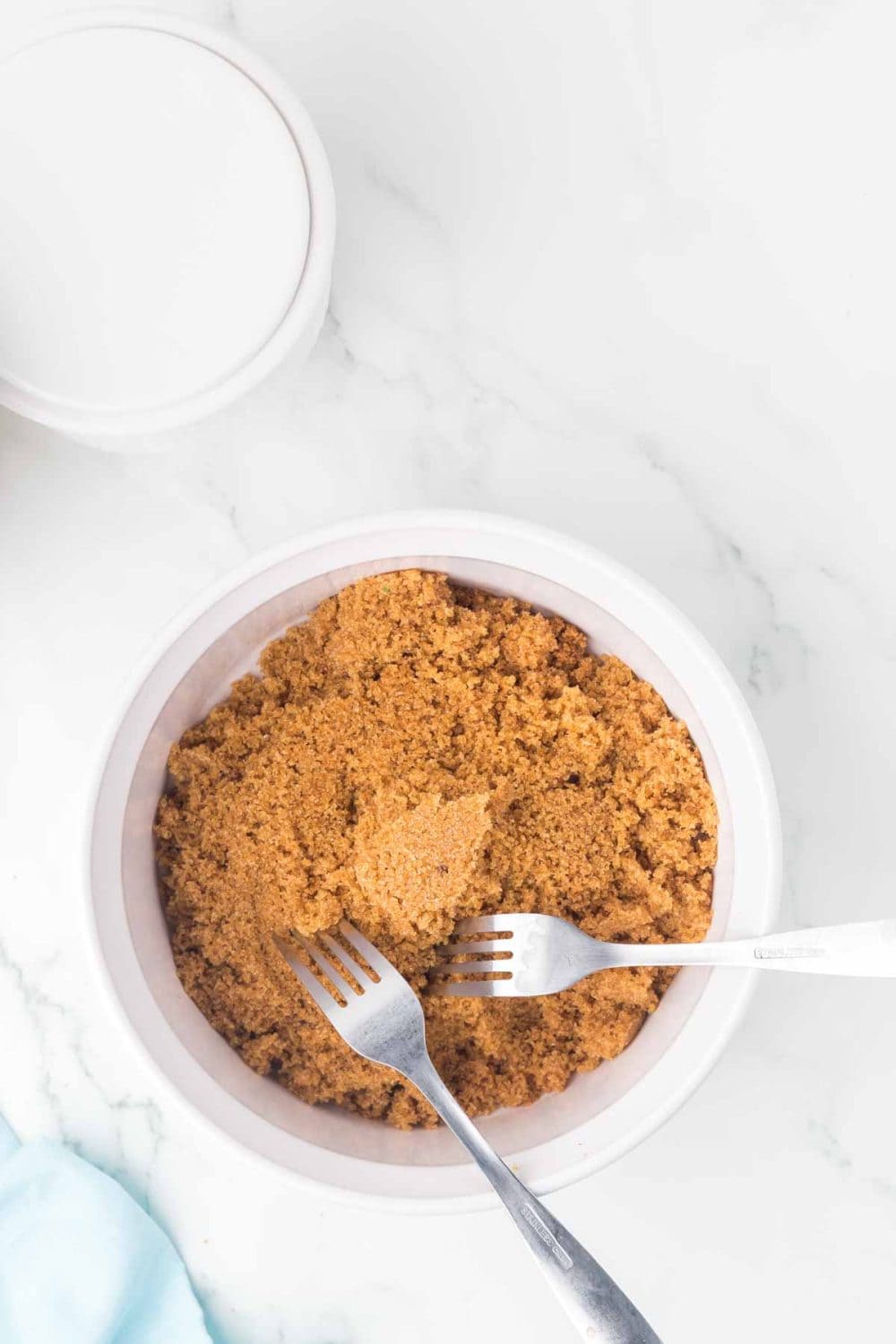 small white dish with softened brown sugar with forks in it