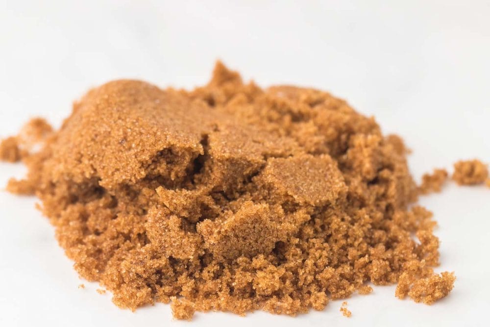 close up of small pile of softened brown sugar on a white countertop