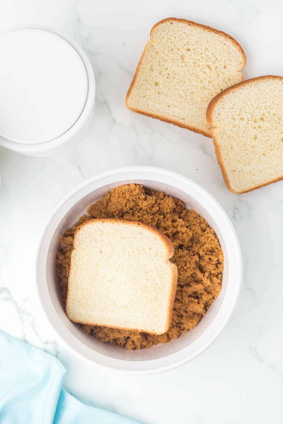 small white dish with softened brown sugar and a slice of bread