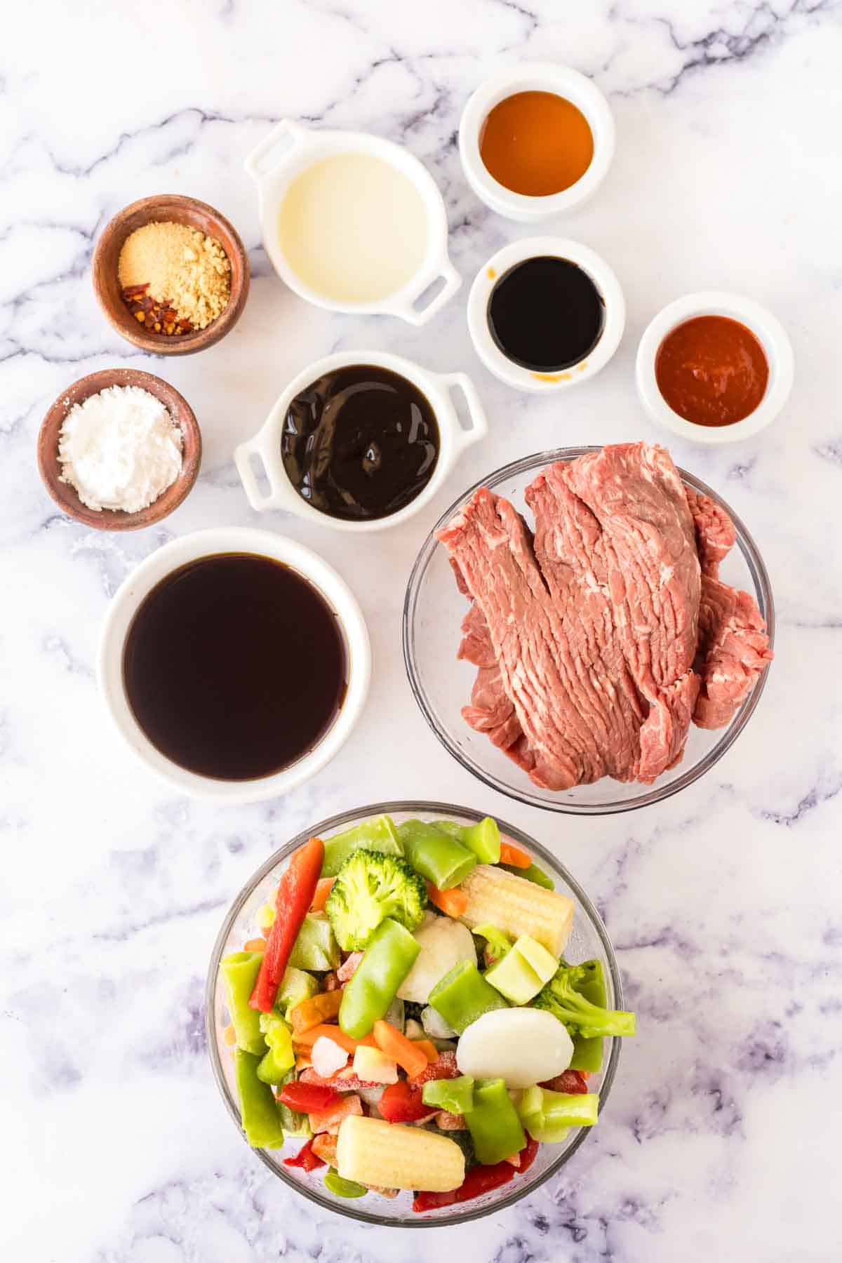 top view of portion dishes with raw ingredients for hunan beef
