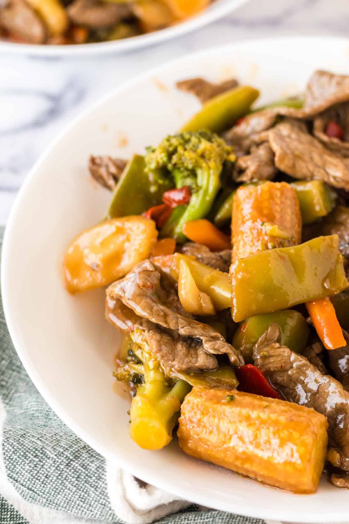 close up top view of a serving of hunan beef in a white bowl