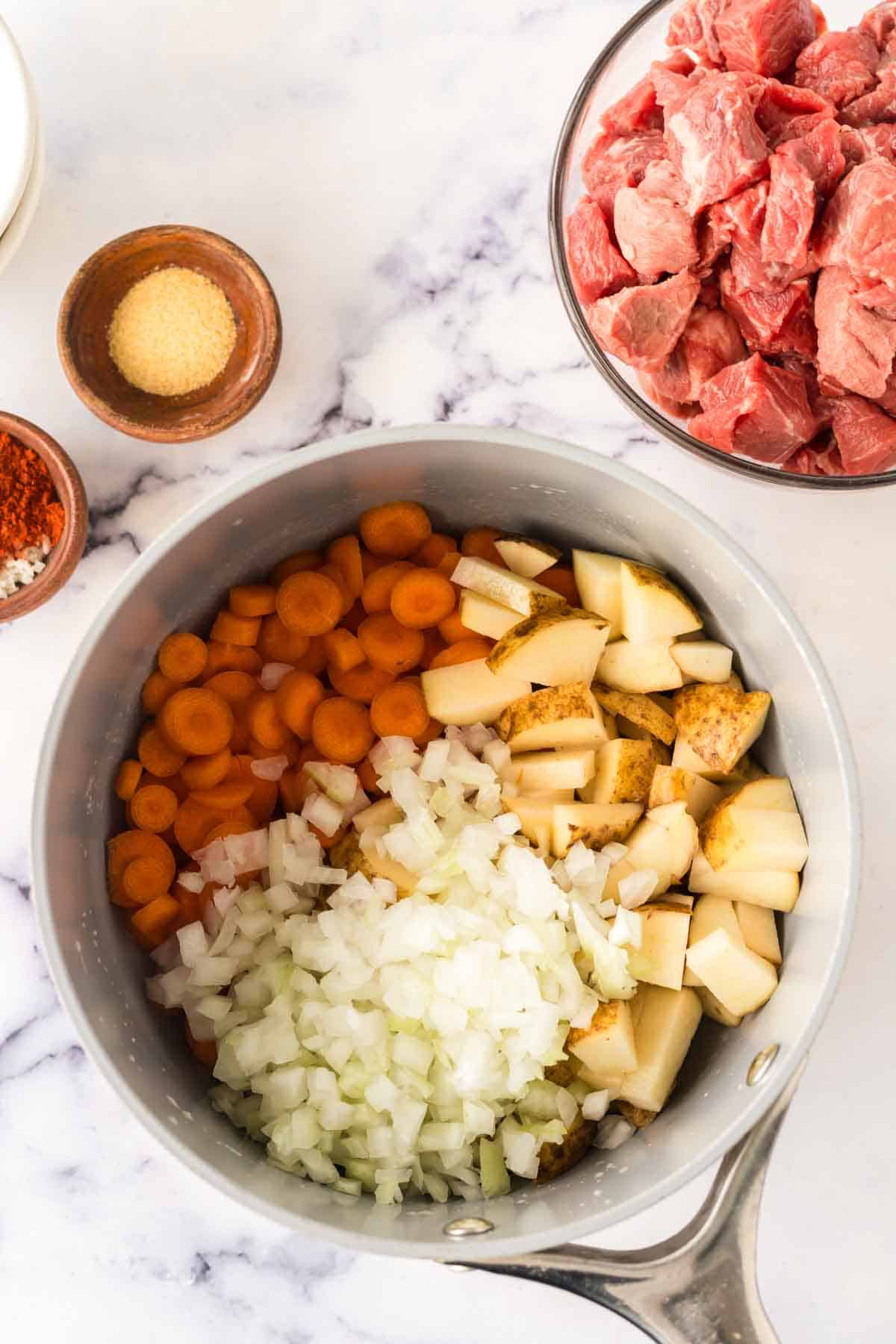 sauce pan with raw ingredients for the Hungarian goulash recipe