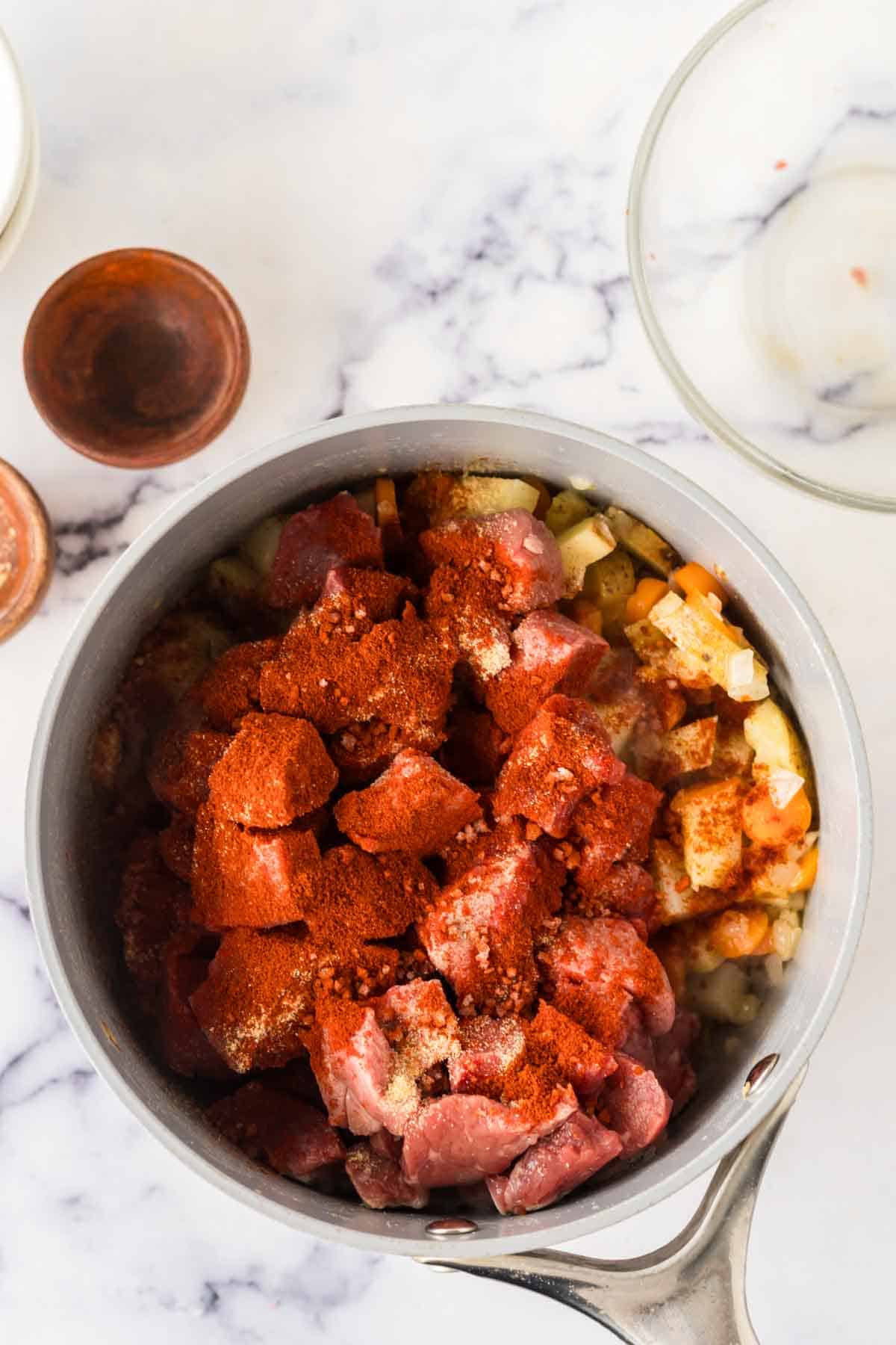 sauce pan with raw ingredients for the Hungarian goulash recipe