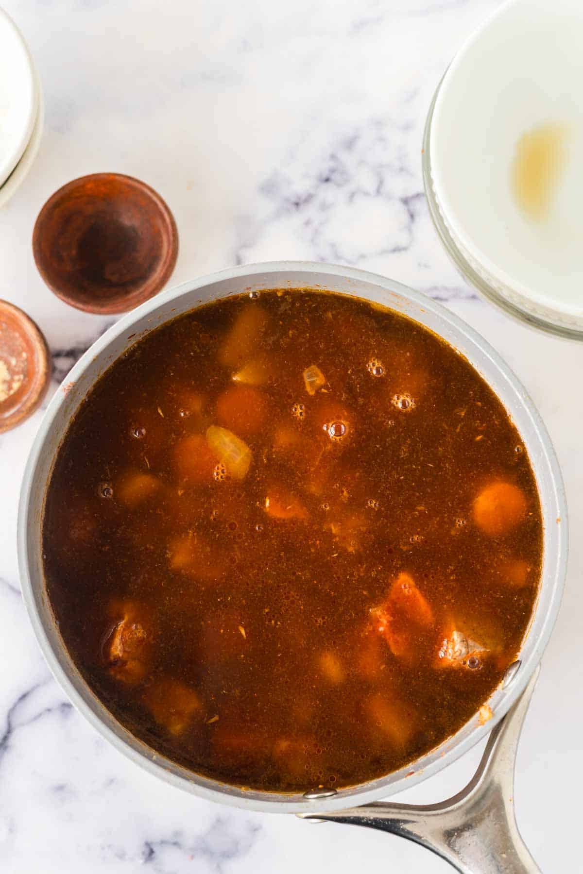 sauce pan with raw ingredients for the Hungarian goulash recipe