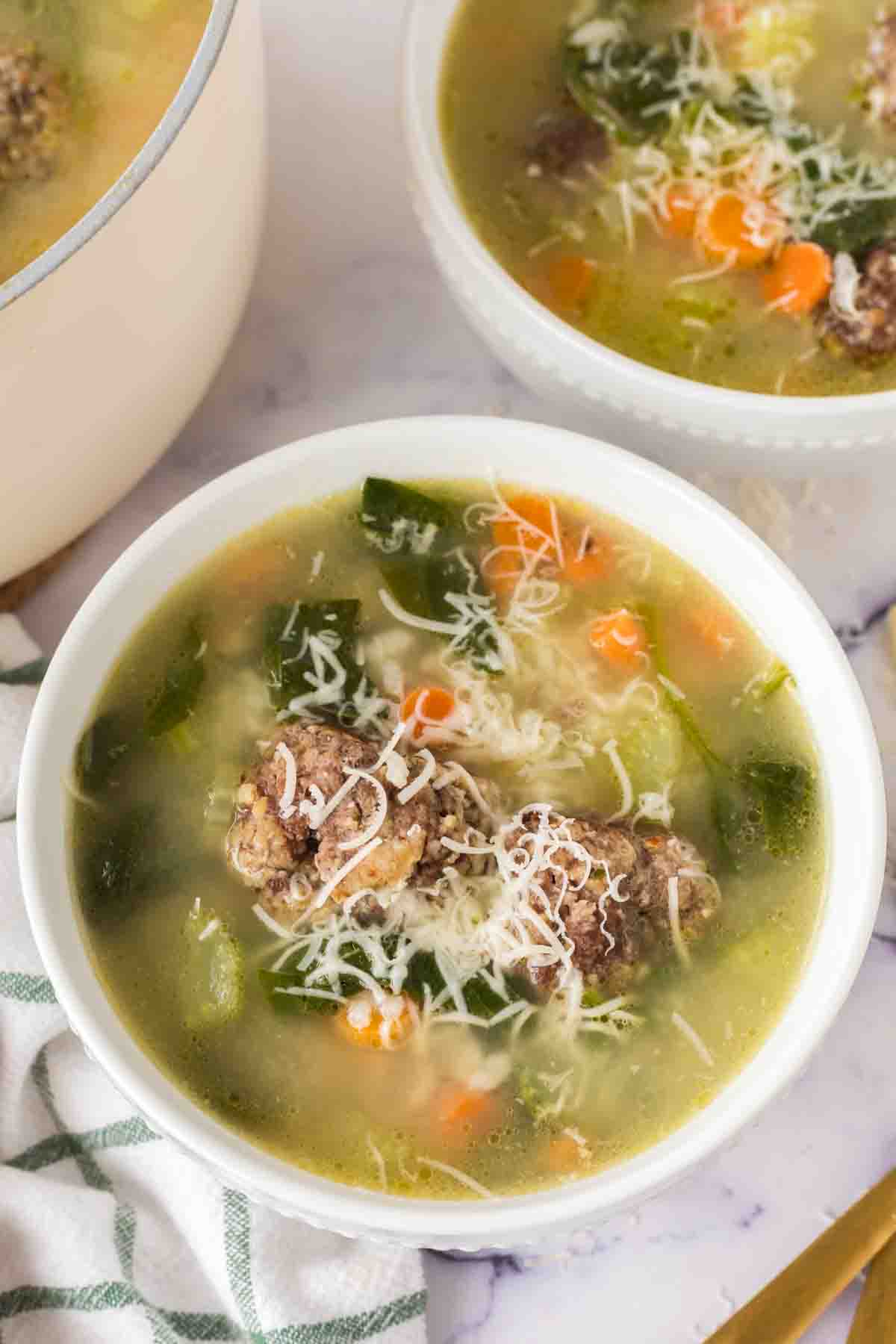 a serving of Italian wedding soup in a white bowl