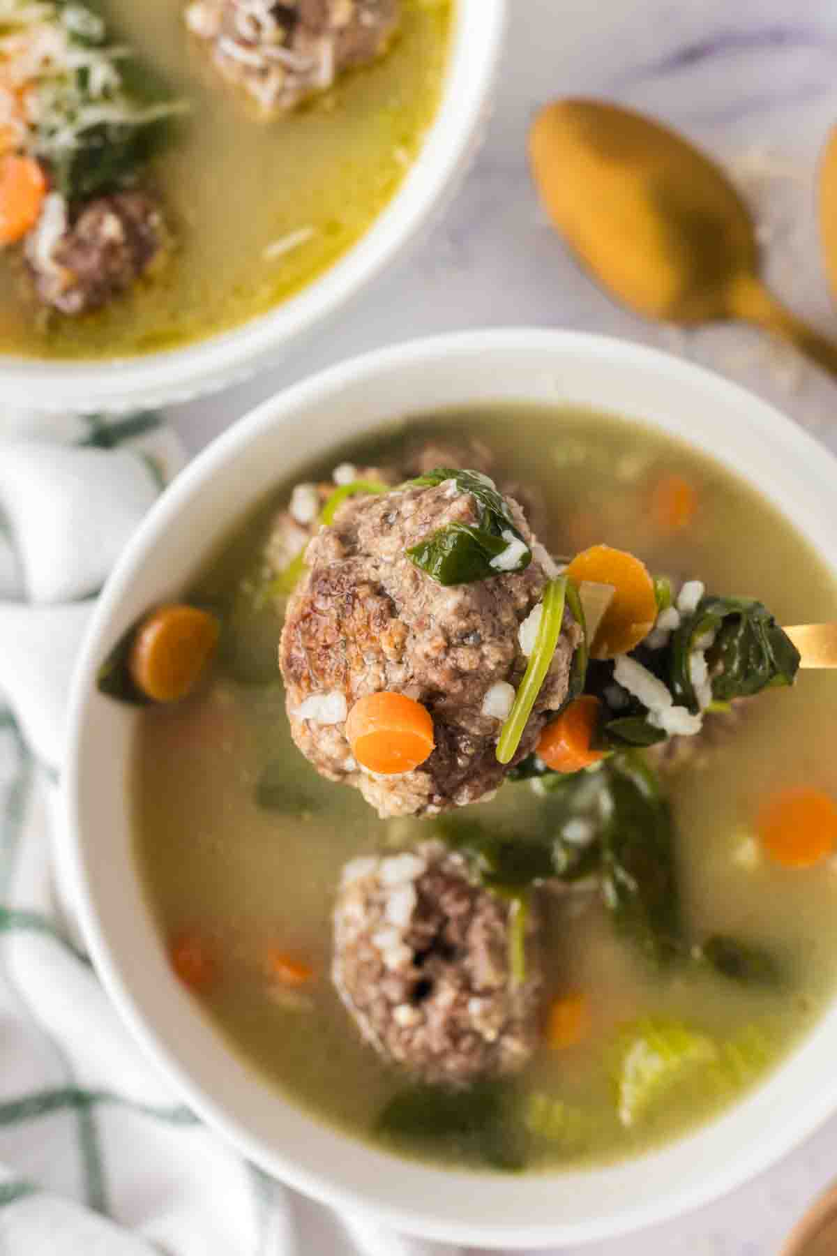 POV top view of a spoonful of italian wedding soup over the bowl