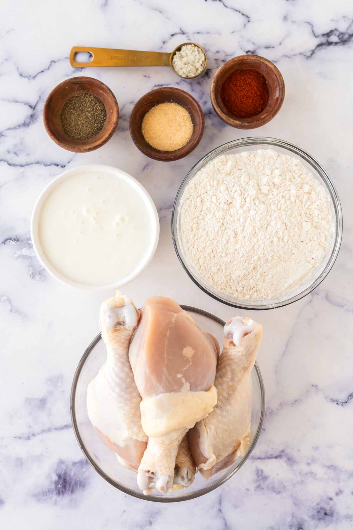 portioned dishes of raw ingredients for Louisiana chicken recipe