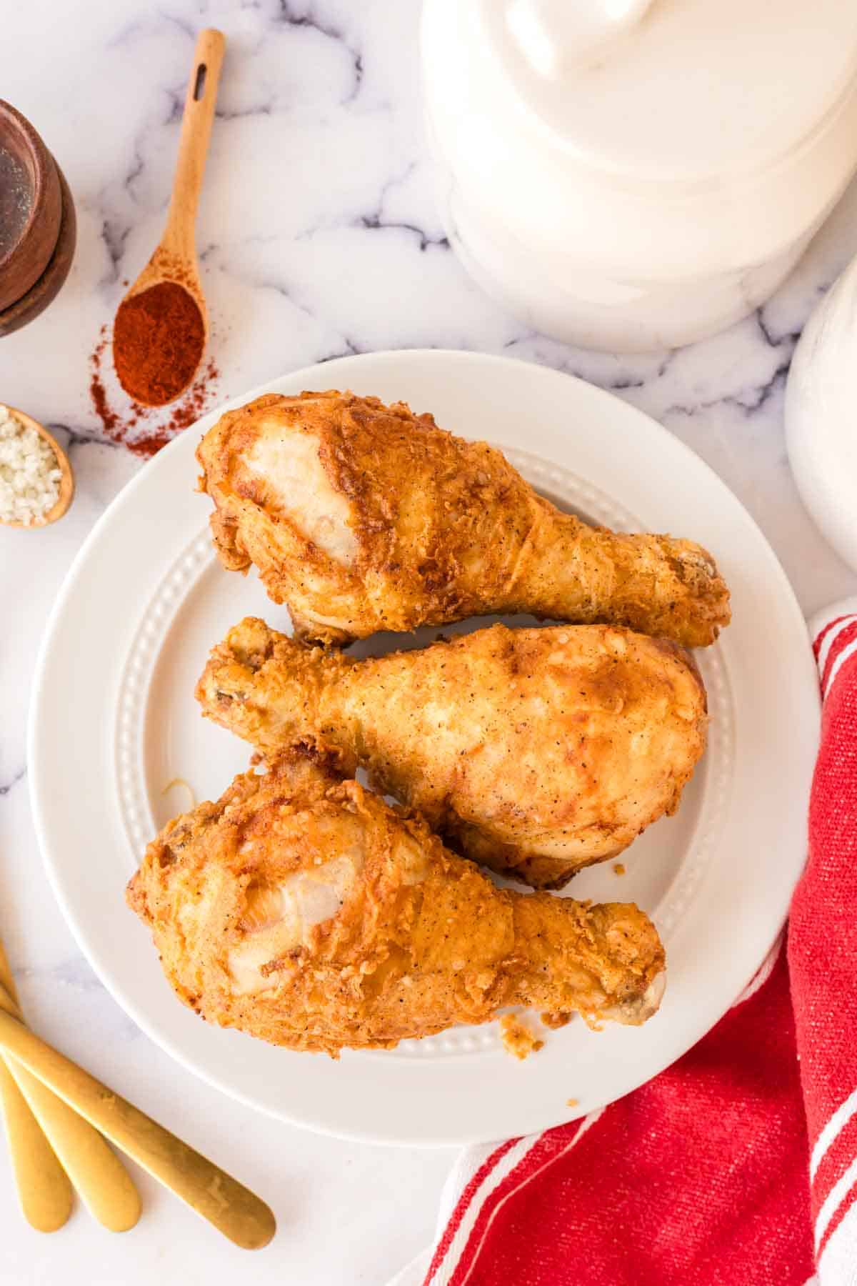 top view of a white plate with three Louisiana chicken legs