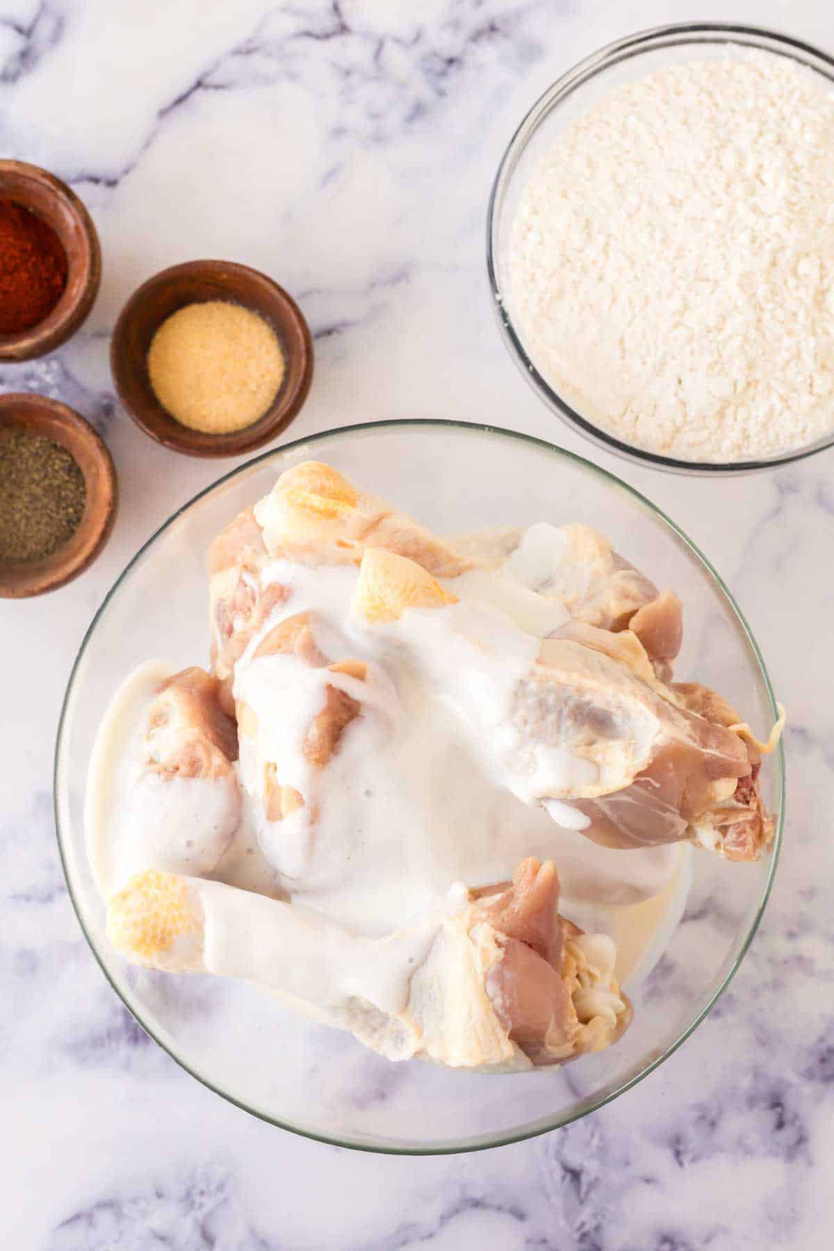 portioned dishes of raw ingredients for Louisiana chicken recipe