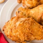 close up of a white plate with three Louisiana chicken legs.