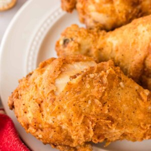 close up of a white plate with three Louisiana chicken legs