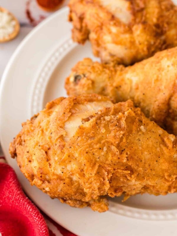 close up of a white plate with three Louisiana chicken legs