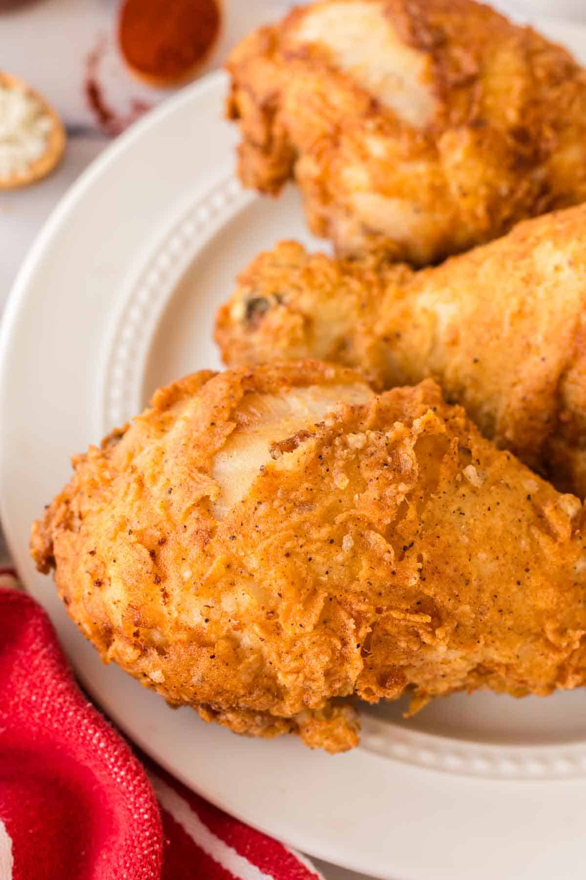 close up of a white plate with three Louisiana chicken legs
