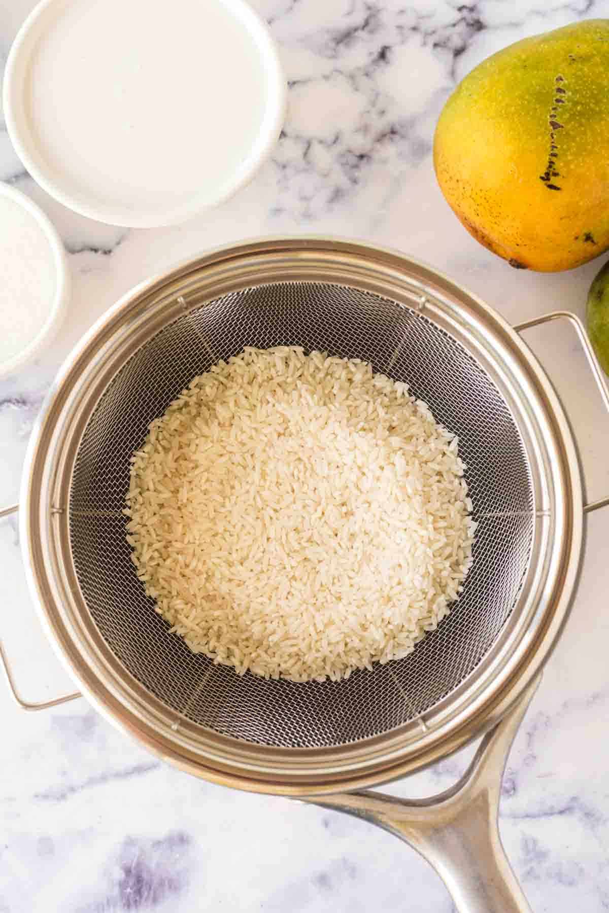 dry rice being washed with a strainer