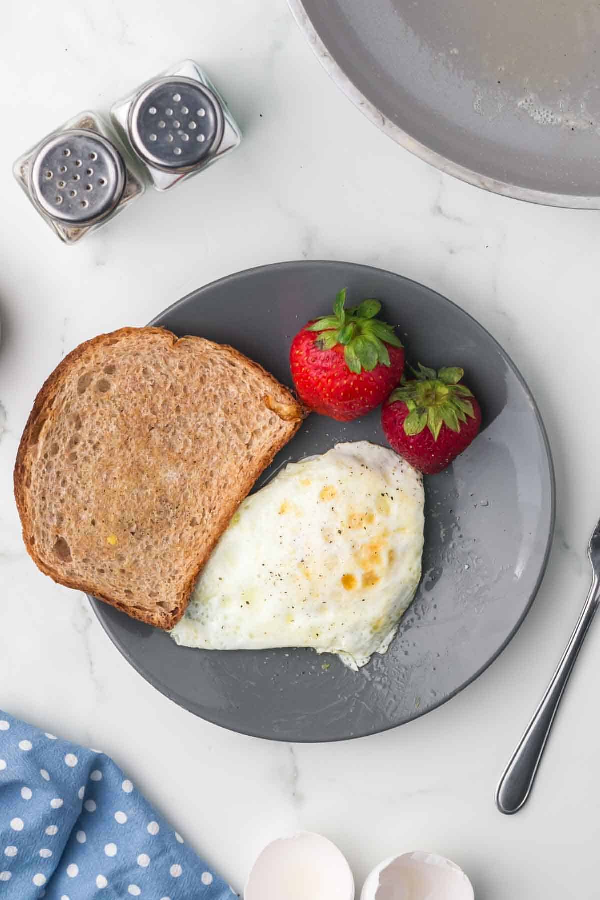 wheat toast with an over easy egg served on a grey plate