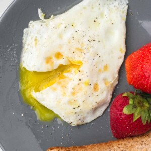 wheat toast with an over easy egg served on a grey plate